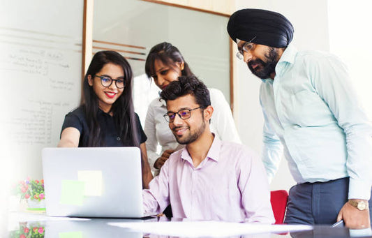 A group of an indian employee looking on a laptop
