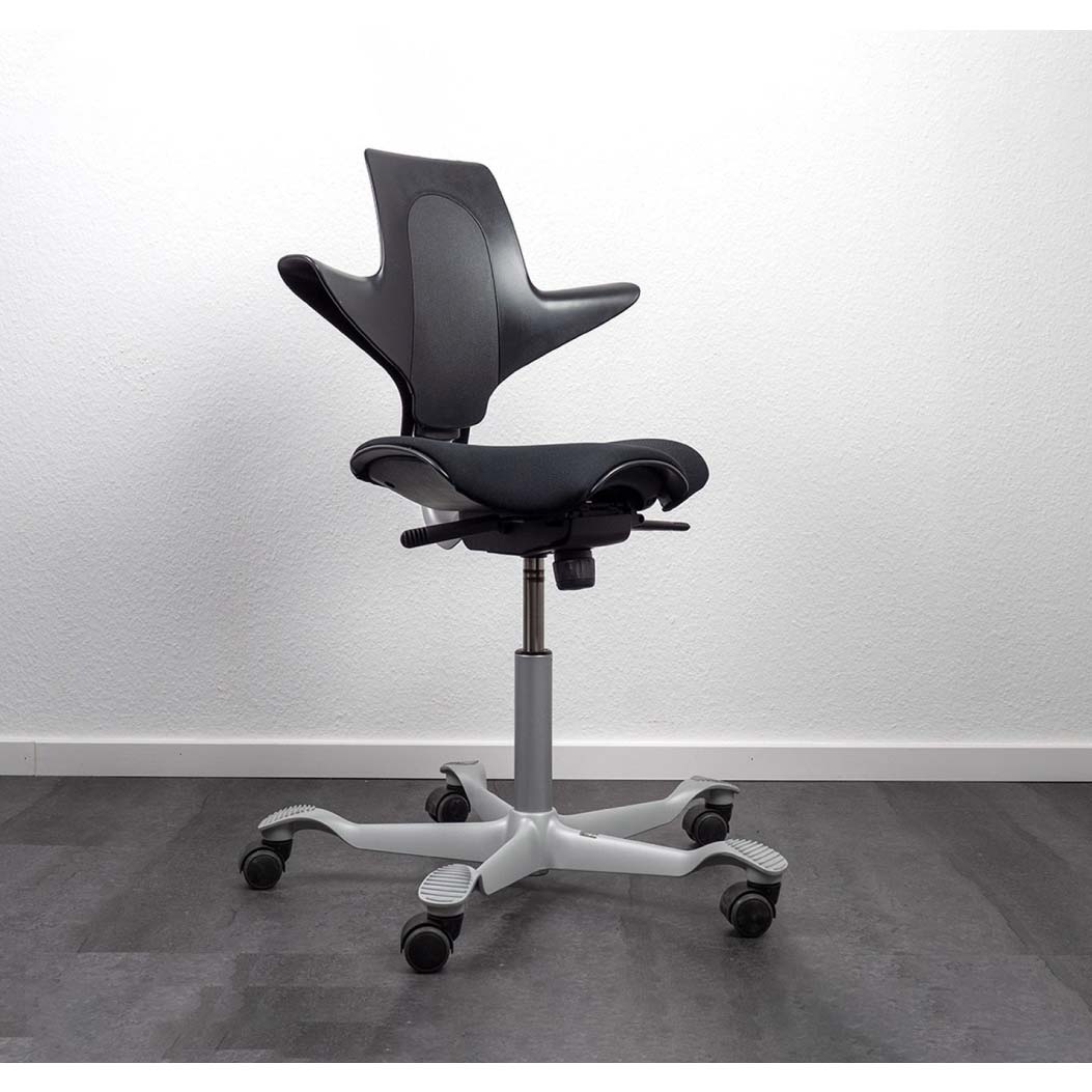 Black office chair with white base on a gray floor and white wall background