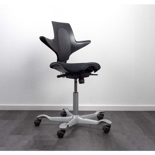 Black office chair with white base on a gray floor and white wall background