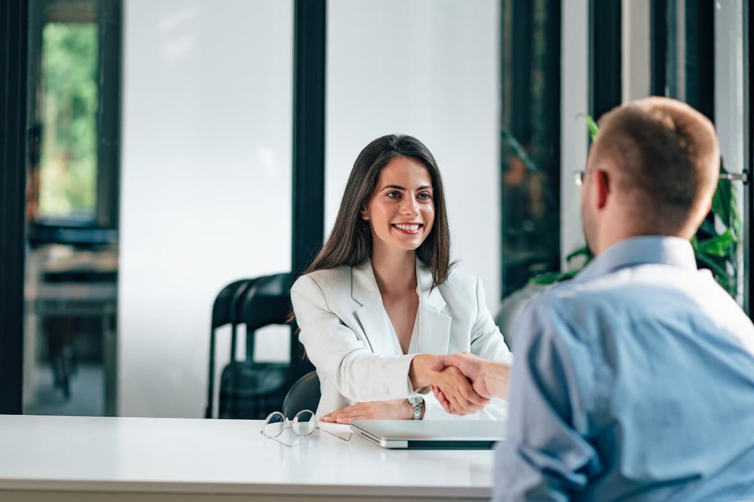 A woman HR shaking a hand of a possible employee.
