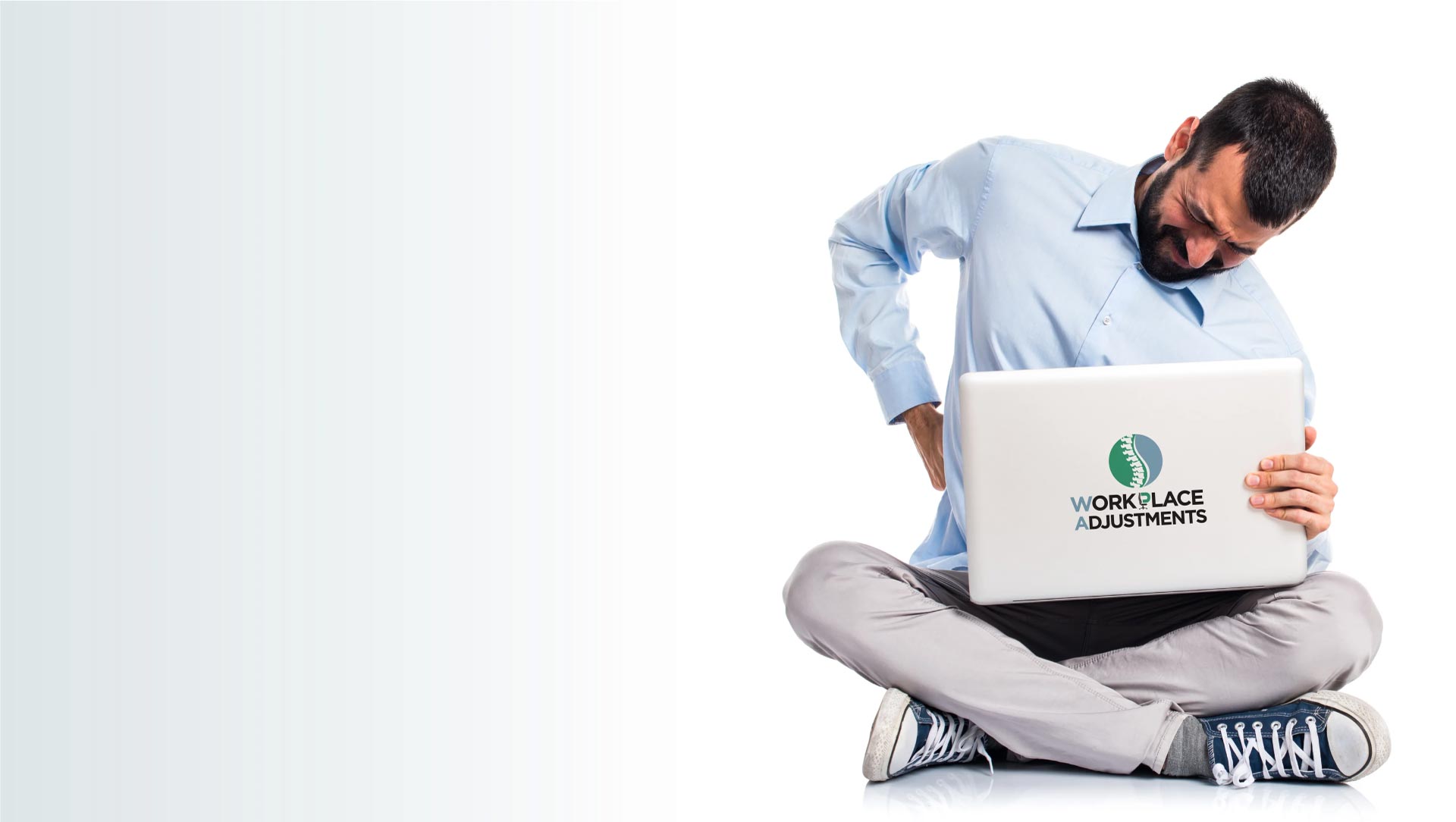 Man sitting cross-legged holding a laptop with 'Workplace Apartments' branding on a white background
