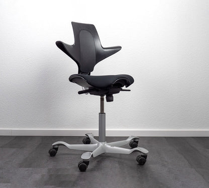 Black office chair with white base on a gray floor and white wall background