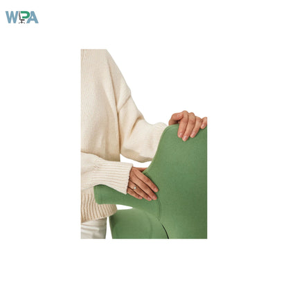 Person wearing a beige sweater holding a green cushion on a white background