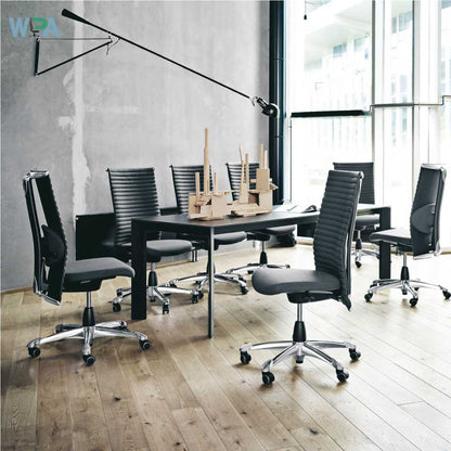Modern office setup with black chairs and a table in a bright room.