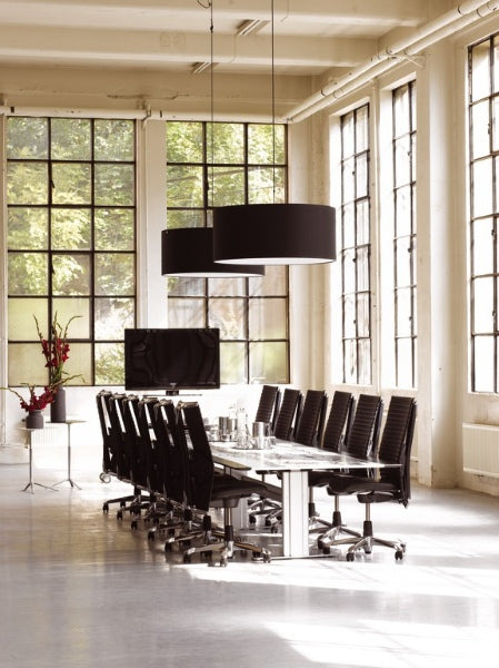 Modern conference room with a long table and chairs, large windows, and decorative elements.