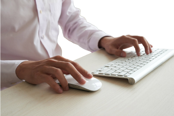 Person using a computer mouse and keyboard on a desk